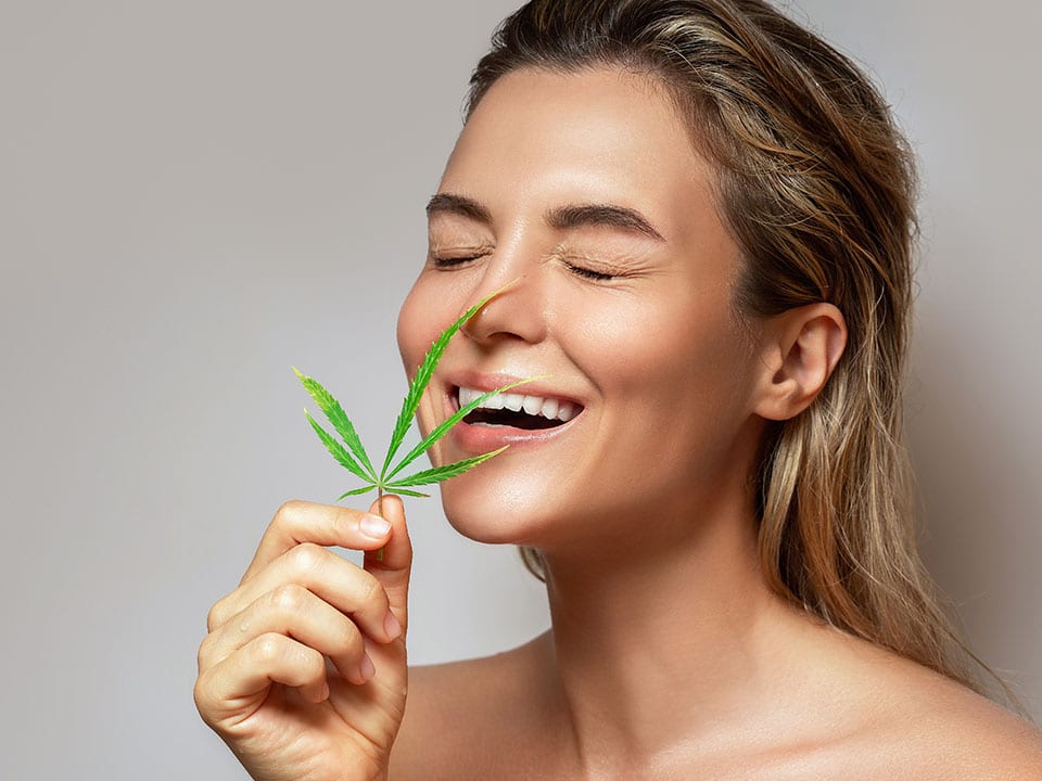 woman smelling hemp plant