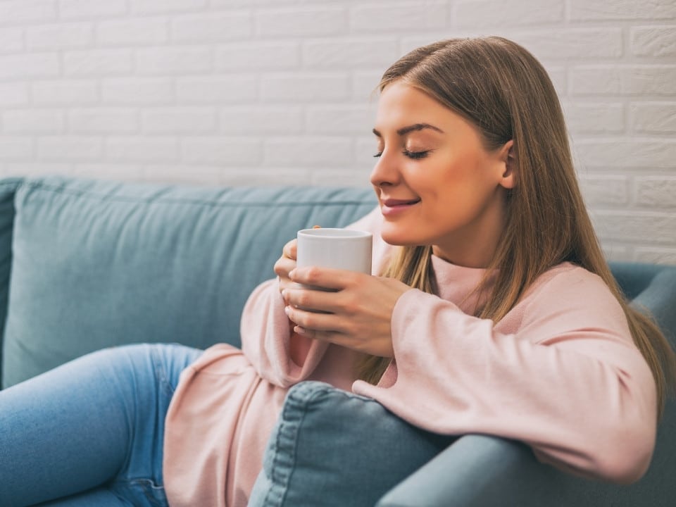 woman having relief while drinking a cbd infused coffee