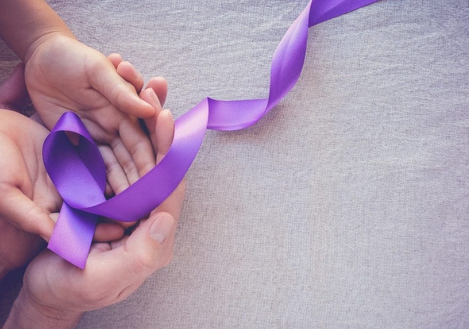 hand holding violet ribbon for epilepsy