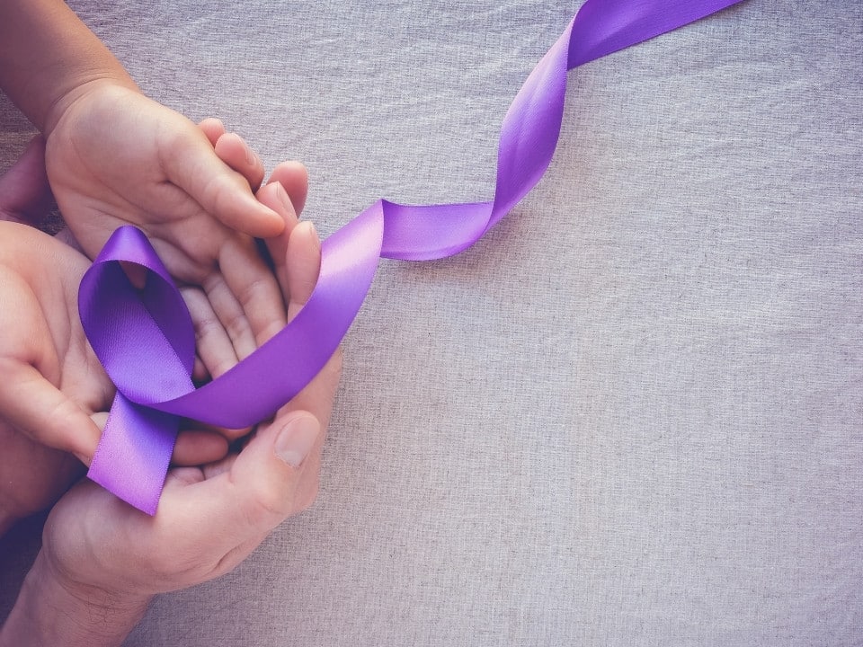 hand holding violet ribbon for epilepsy