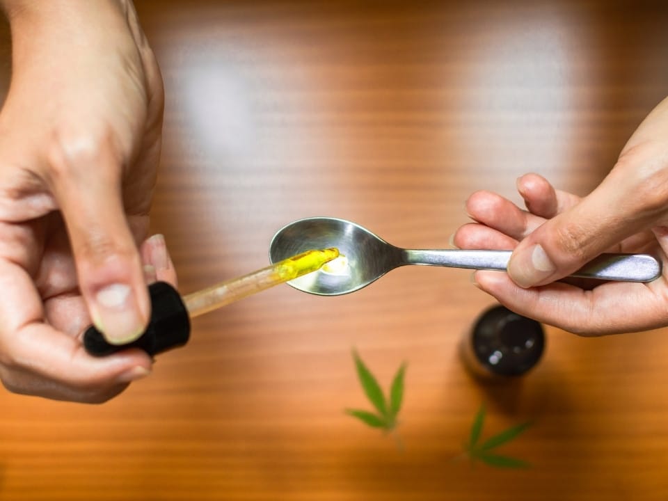 putting cbd oil in a tea spoon