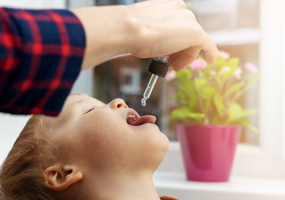 mother giving cbd drops to her kid