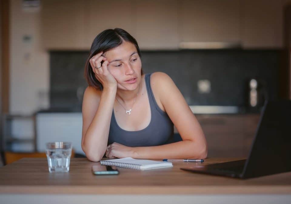 woman experiencing brain fog while looking at her laptop