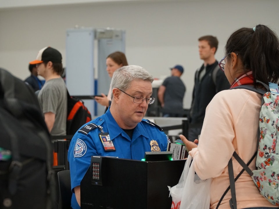 tsa worker checking out the passport of a passenger