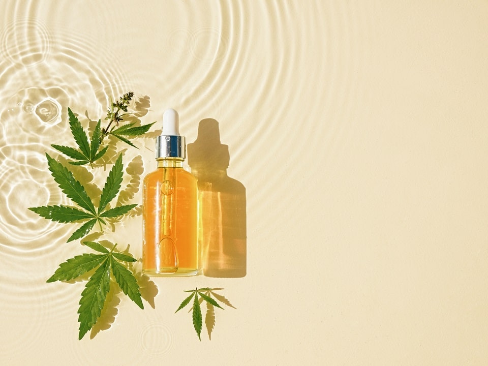 cbd oil in a beach sand