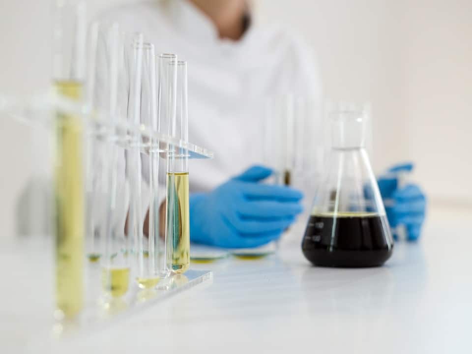 cbd oil vials in a lab with a scientist experimenting them