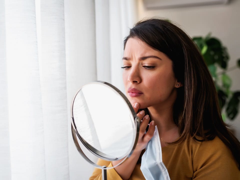 woman checking her acne