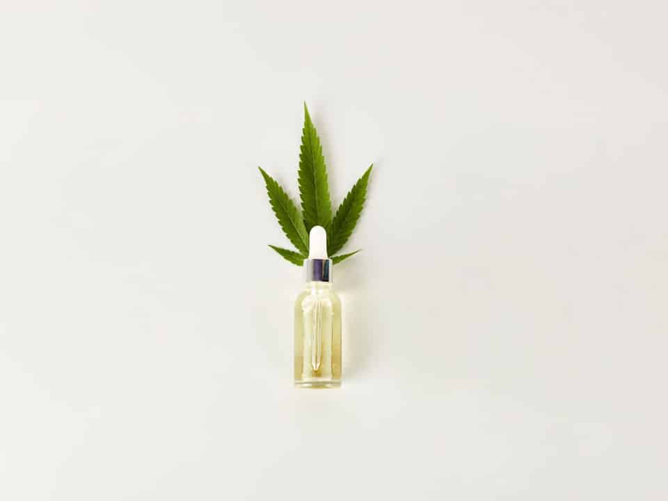 cbd oil with a hemp on the back on a white background