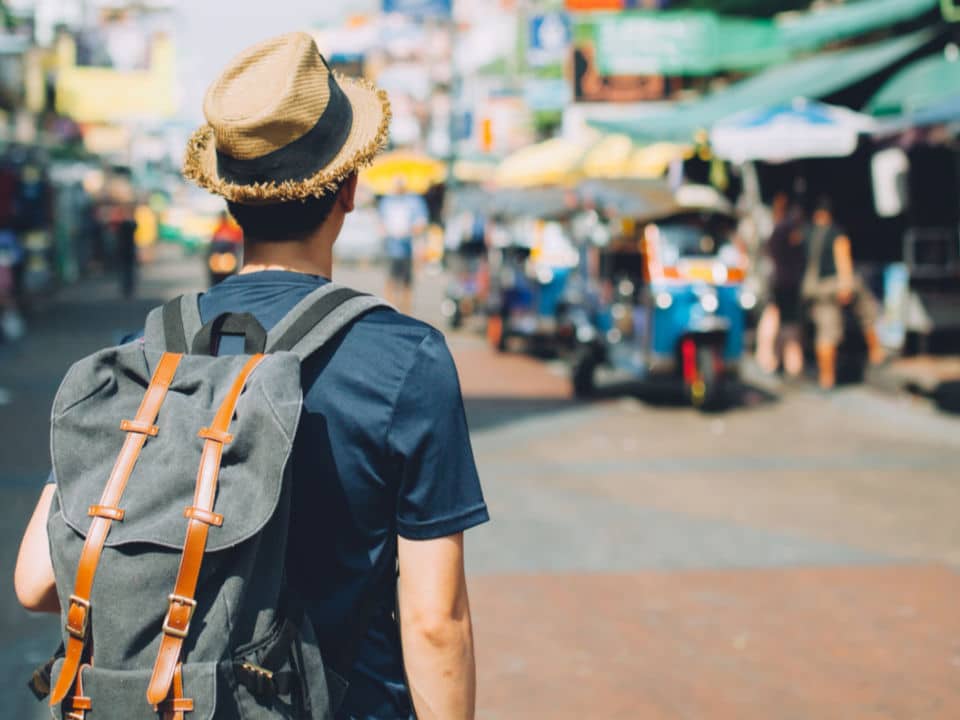 man with backpack walking in the street