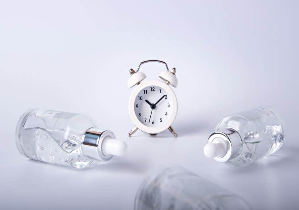 three bottles of cbd oil and a clock in white background