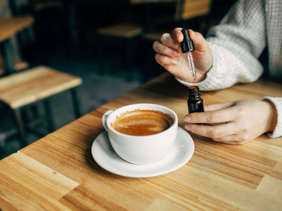 adding cbd oil in a cup of coffee