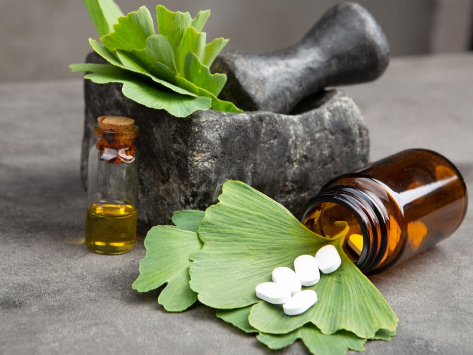 bottle of cbd oil and gingko biloba leaves and pills