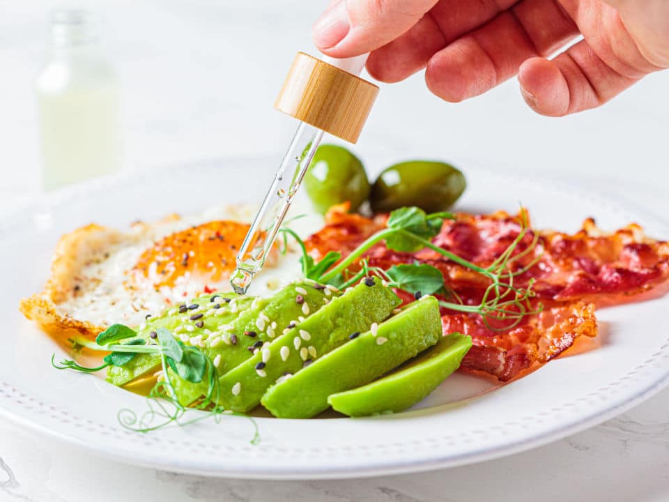 cbd oil drip into plate with keto breakfast