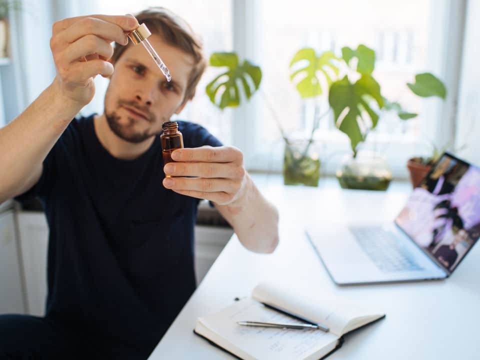 man taking cbd oil to improve his focus on work
