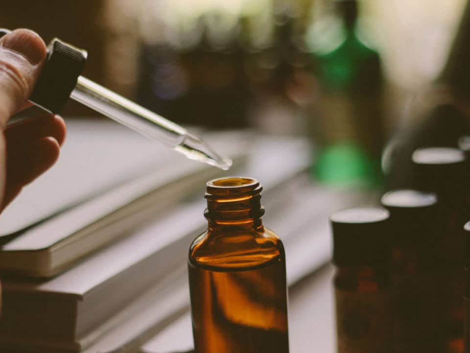 woman taking drops from cbd tincture