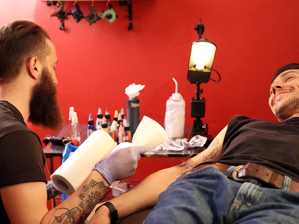 professional tattoo artist and his satisfied client